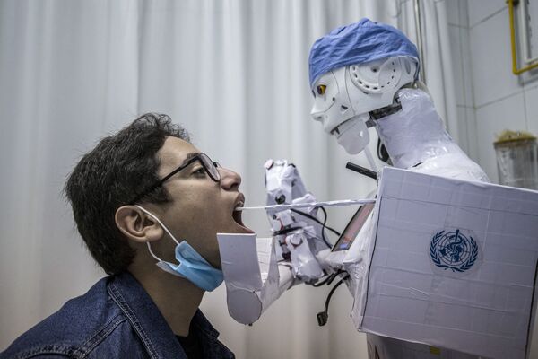رجل آلي يأخذ مسحة لاجراء فحص كوفيد-19 في طنطا، في إطار الحد من انتشار فيروس كورونا في مصر، 20 مارس 2021 - سبوتنيك عربي