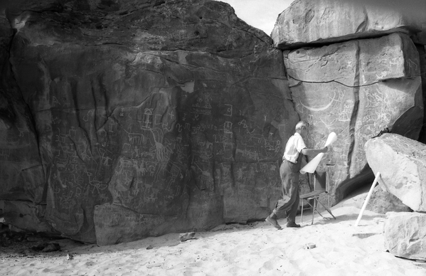 ف. ف. بيمينوف يستعد لنقل ورسم النقوش من على أحد الصخور على ورقة للرسم رطبة الملمس في منطقة أم عشيرة، عام 1962 - سبوتنيك عربي