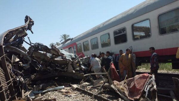 مواطنون يتفقدون الأضرار بعد اصطدام قطارين قرب مدينة سوهاج، 26 مارس/ آذار 2021 - سبوتنيك عربي
