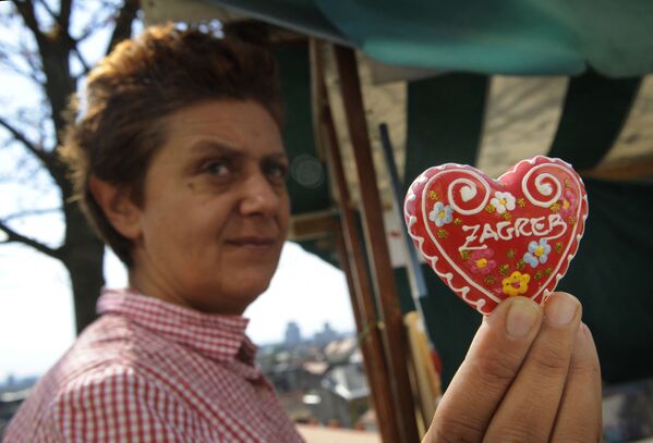 امرأة تحمل قلب ليسيتار - تذكار حلوى كرواتي تقليدي في مدينة زغرب، كرواتيا، 24 سبتمبر 2012 - سبوتنيك عربي