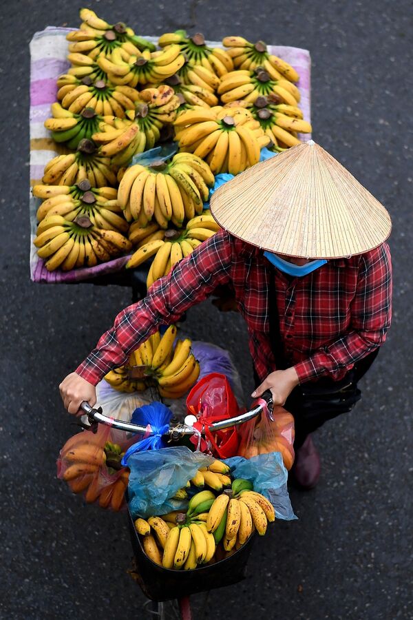 بائع متجول يحمل الموز على دراجته في أحد شوارع مدينة هانوي، فيتنام 18 مارس 2021 - سبوتنيك عربي