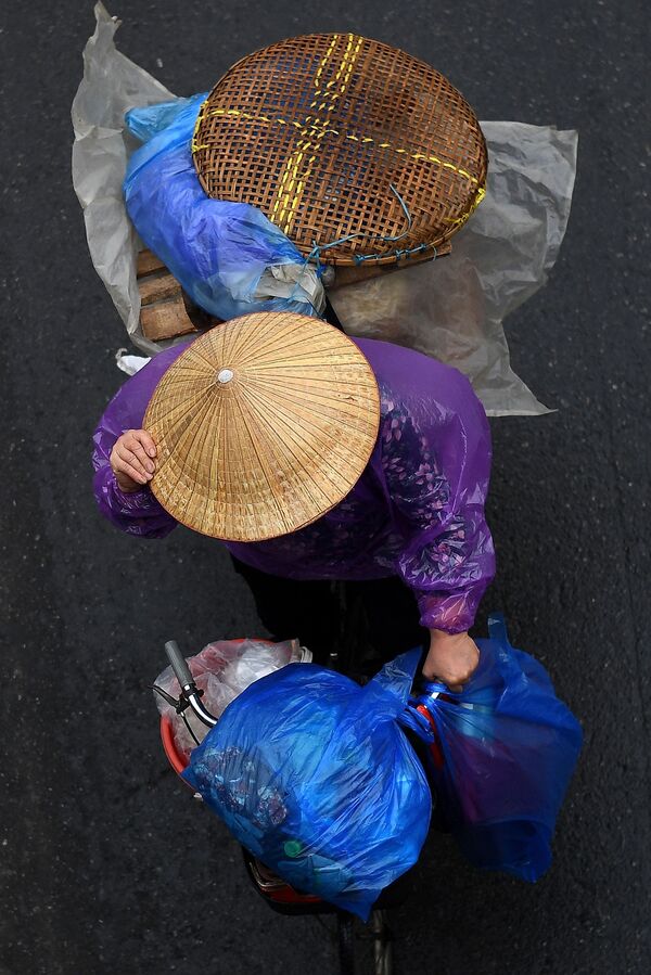 بائع متجول يحمل الأغراض على دراجته في أحد شوارع مدينة هانوي، فيتنام 18 مارس 2021 - سبوتنيك عربي