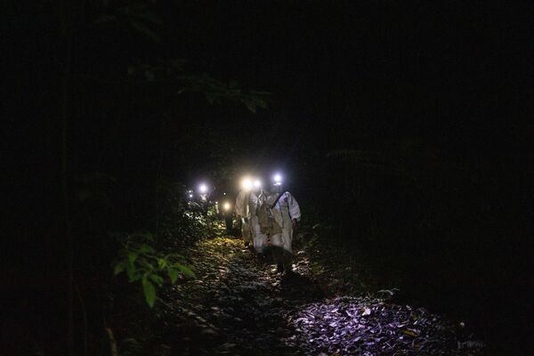 أخصائي علم الخفافيش، كيرك تاراي، يقود مجموعة من الأخصائيين، حاملاً صندق به خفافيش، في منطقة جبل ماكيلينغ ​في لوس بانوس، مقاطعة لاغونا، الفلبين، 5 مارس 2021 - سبوتنيك عربي