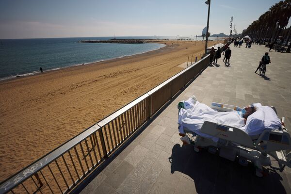 المريض جوان سولير سيندرا، 63 عامًا، وهو أصم وبكم، ينظر إلى البحر بجوارالأطباء (الذين يقفون خلف الصورة) كجزء من جلسة العلاج البحري، بعد 114 يومًا من دخوله مستشفى ديل مار بسبب مرض فيروس كورونا ( كوفيد-19) في برشلونة، إسبانيا، 25 مارس 2021 - سبوتنيك عربي