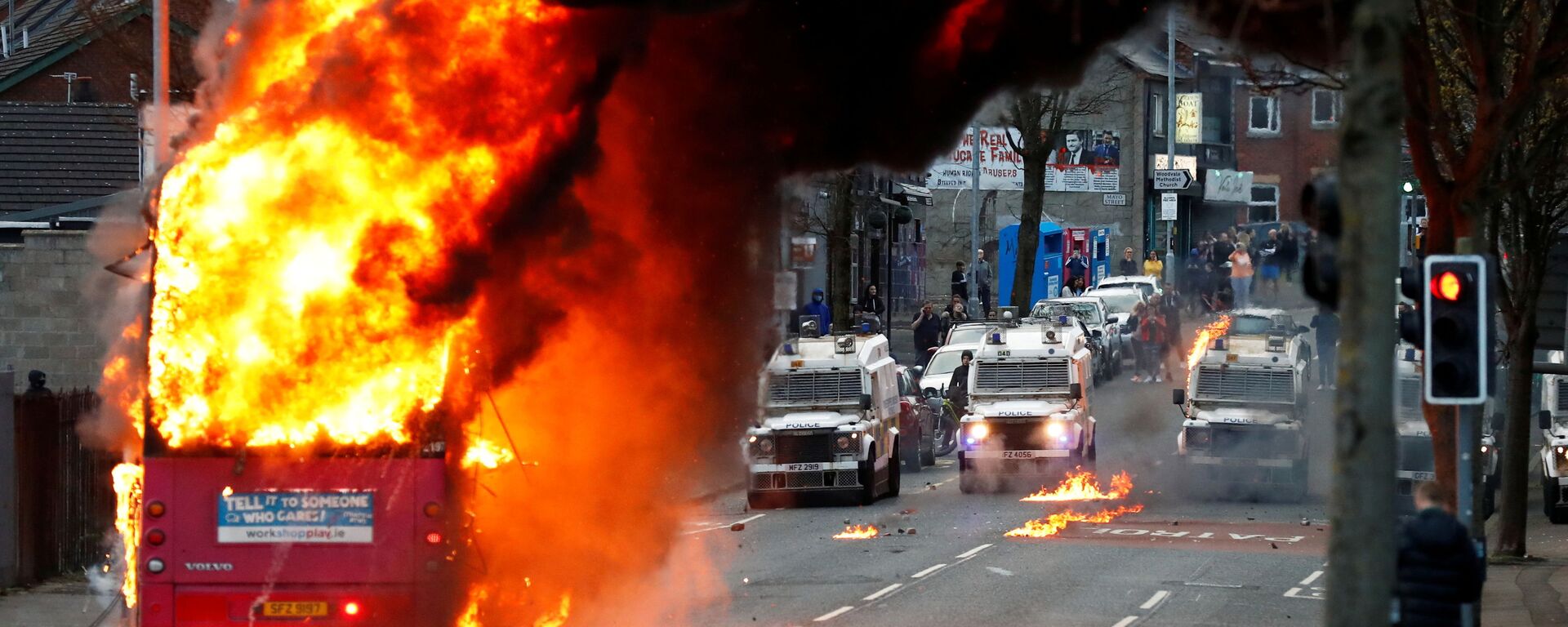 سيارات الشرطة تظهر خلف حافلة مخطوفة تحترق على طريق شانكيلЛ مع استمرار الاحتجاجات في بلفاست، أيرلندا الشمالية، 7 أبريل 2021 - سبوتنيك عربي, 1920, 09.04.2021