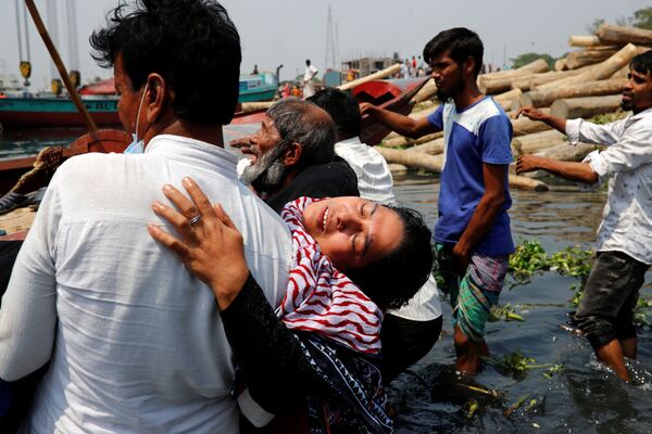 أقارب في حزن بعد وفاة عدة أشخاص عندما اصطدمت عبارة بسفينة شحن وغرقت في نهر شيتالاكسيا في نارايانغانج، بنغلاديش، 5 أبريل 2021 - سبوتنيك عربي