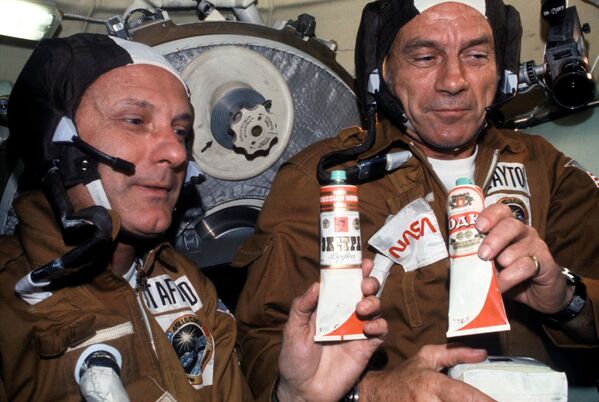 رائدا الفضاء الأمريكيان توماس ستافورد ودونالد كنت يمسكان أنابيب الطعام في مركبة الفضاء السوفيتية سويوز - سبوتنيك عربي