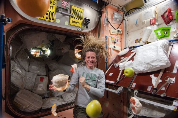 رائدة فضاء ناسا كارين نيبيرج، مهندسة رحلة لبعثة رقم 36، تظهر بالقرب من فاكهة طازجة تطفو بحرية في محطة الفضاء الدولية. - سبوتنيك عربي
