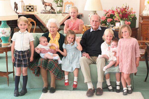 دوق إدنبرة الأمير فيليب يجلس برفقة زوجته ملكة بريطانيا إليزابيث الثانية، وأحفاد أحفادهم في قصر باكينغهام، في صورة نشرها القصر بتاريخ 14 أبريل 2021 - سبوتنيك عربي