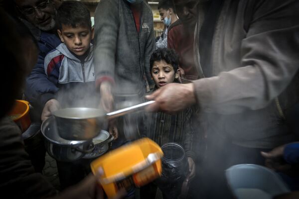 صبي ينتظر دوره للحصول على وجبة إفطار، خلال فعالية خيرية لمساعدة المحتاجين والفقراء في شهر رمضان، مدينة غزة، قطاع غزة، فلسطين 14 أبريل 2021 - سبوتنيك عربي