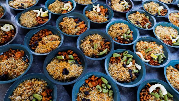 أواني من الأرز المطبوخ والفواكه جاهزة للتوزيع على الصائمين قبيل إفطار رمضان،  وسط اجراءات احترازية بسبب مرض فيروس كورونا (كوفيد-19) في كراتشي، باكستان، 17 أبريل 202 - سبوتنيك عربي