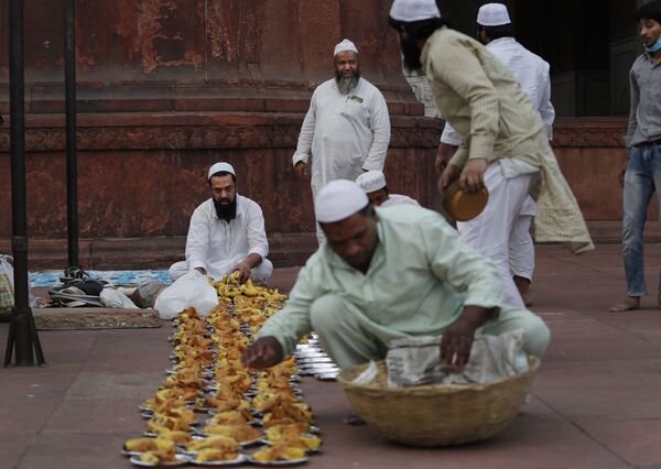 يقوم المسلمون بإعداد أطباق مع وجبات خفيفة لتوزيعها على الإفطار في اليوم الأول من شهر رمضان في المسجد الجامع في نيودلهي، الهند 14 أبريل 2021 - سبوتنيك عربي