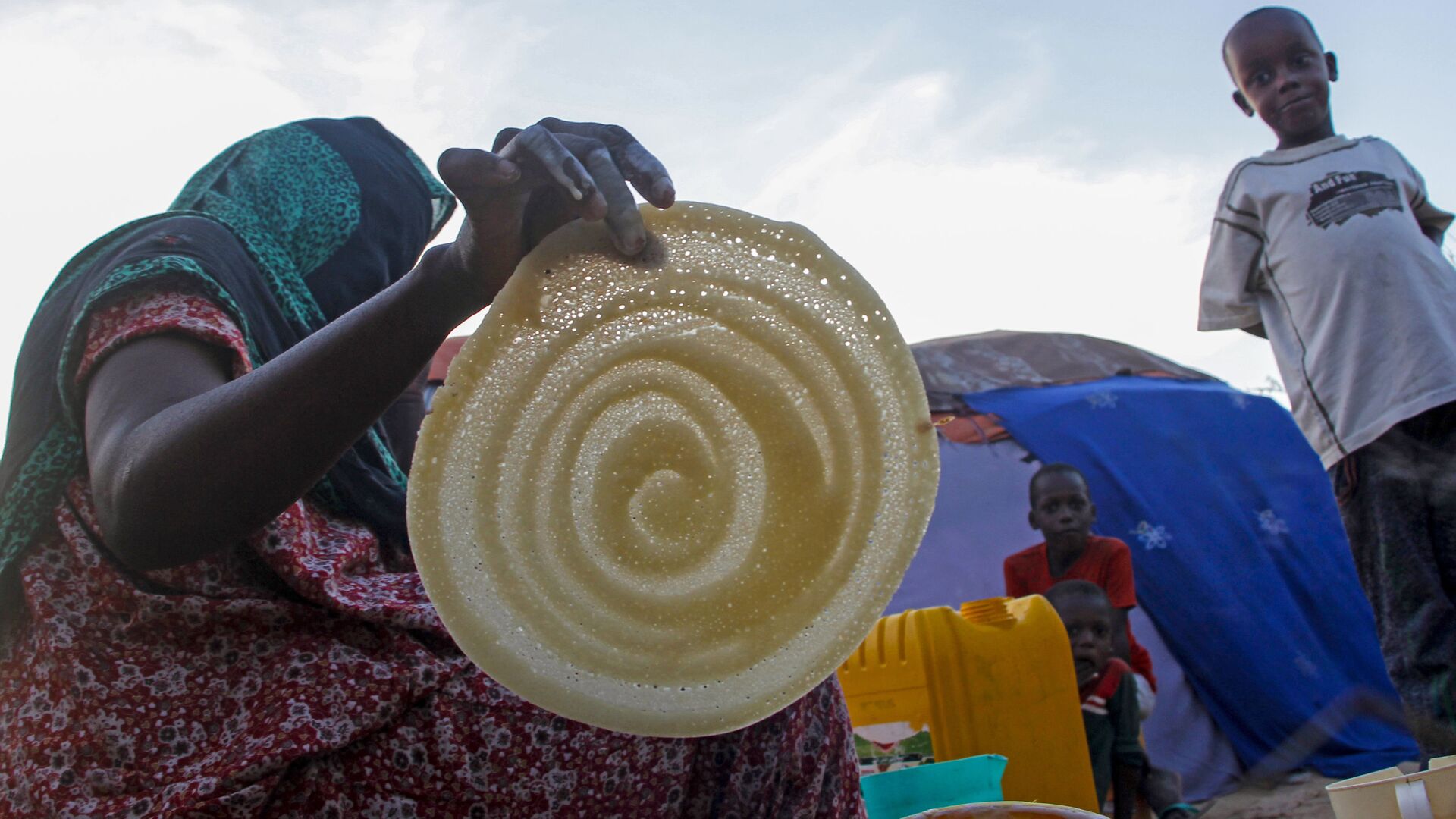 امرأة صومالية تصنع الفطائر لعائلتها في رمضان، في مخيم للنازحين في حي دار السلام بالعاصمة مقديشو، الصومال، 16 أبريل 2021 - سبوتنيك عربي, 1920, 23.11.2021