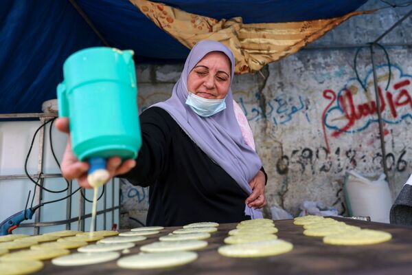 الفلسطينية مريم صالحة تصنع القطايف، حلويات تقليدية في شهر رمضان في دير البلح وسط قطاع غزة، فلسطين 19 أبريل 2021 - سبوتنيك عربي