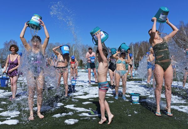أشخاص يسكبون الماء على أنفسهم في إطار فعالية ربيعية سنوية الصحوة، في المدينة السيبيرية تومسك، روسيا 17 أبريل 2021 - سبوتنيك عربي