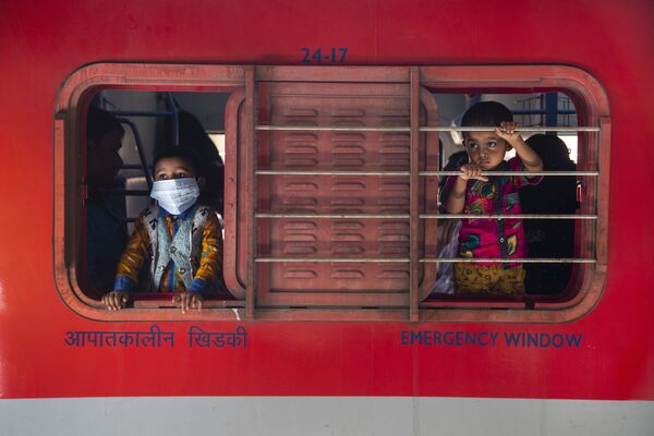 أطفال صغار ينظرون من نوافذ قطار على السكة الحديدية في غاهاتي، الهند 19 أبريل 2021. تحتل الهند الآن المركز الثاني من حيث حالات الإصابة بمرض كوفيد-19 بعد الولايات المتحدة - سبوتنيك عربي