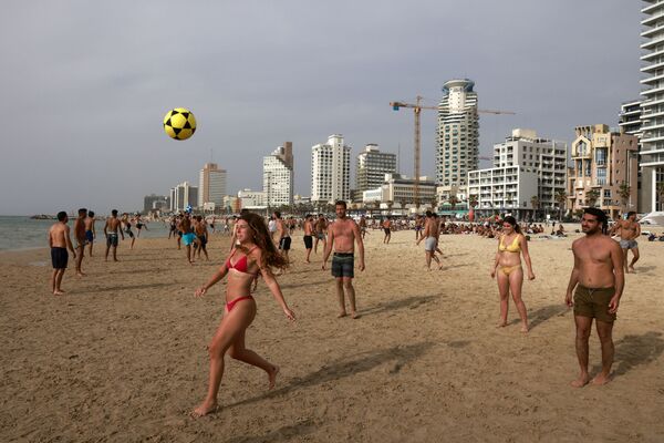 مواطنون إسرائيليون يلعبون كرة القدم على شاطئ البحر في مدينة تل-أبيب، بعد إعلان السلطات الإسرائيلية أنه لم تعد هناك حاجة للكمامات للوقاية من كوفيد-19 في الخارج، 19 أبريل 2021 - سبوتنيك عربي