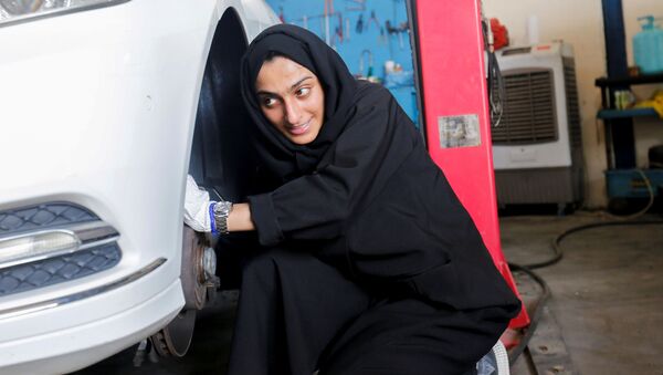 الإماراتية هدى المطروشي، 36 عاماً، تملك وتدير كراجاً لتصليح السيارات، تقوم بتصليح عجلة السيارة في كراجها في الشارقة، الإمارات العربية المتحدة، 21 أبريل 2021 - سبوتنيك عربي