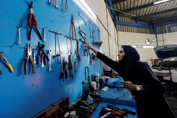 الإماراتية هدى المطروشي، 36 عاماً، تملك وتدير كراجاً لتصليح السيارات، تختار آلة تصليح في كراجها في الشارقة، الإمارات العربية المتحدة، 21 أبريل 2021 - سبوتنيك عربي