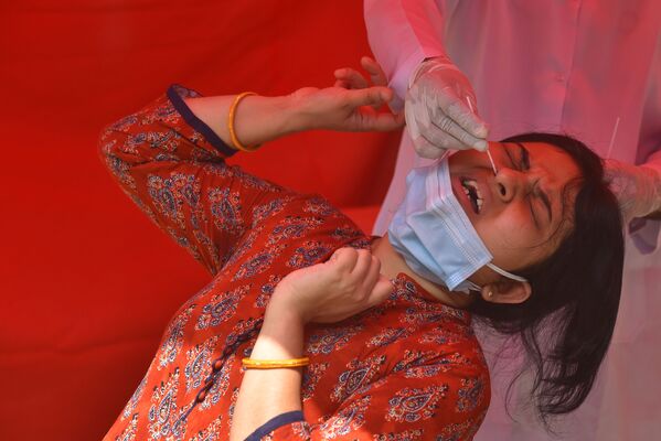 كارثة إنسانية كبرى - تسجيل أرقام قياسية لحالات الإصابة بمرض كوفيد-19، امرأة شابة تلجأ لاختبار كورونا في نيودلهي، الهند 28 أبريل 2021 - سبوتنيك عربي