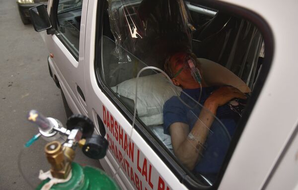 كارثة إنسانية كبرى - تسجيل أرقام قياسية لحالات الإصابة بمرض كوفيد-19،رجل داخل سيارة إسعاف ينتظر دوره لتلقي جرعة الأكسجين و الدعم الطبي في أحد معابد غورودفار في نيودلهي، الهند 28 أبريل 2021 - سبوتنيك عربي