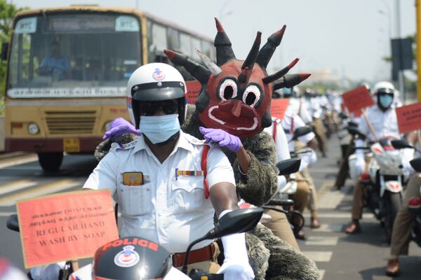  شخص من منظمة غير حكومية يرتدي زي شرطي كورونا لنشر الوعي عن الاجراءات الوقائية لمنع الإصابة بكورونا في سيليغوري، الهند 28 أبريل 2021 - سبوتنيك عربي