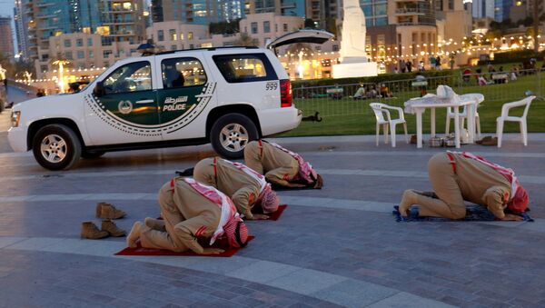 أفراد من شرطة الإمارات يصلون بعد الإفطار خارج مبنى دبي مول ، الإمارات العربية المتحدة، 23 أبريل 2021 - سبوتنيك عربي