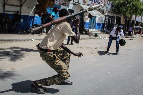 شخص يلتقط صورة لعضو في القوة العسكرية الصومالية يدعم المناوئين للحكومة أثناء وقوفه في أحد شوارع مقديشو، الصومال، 25 أبريل 2021 - سبوتنيك عربي