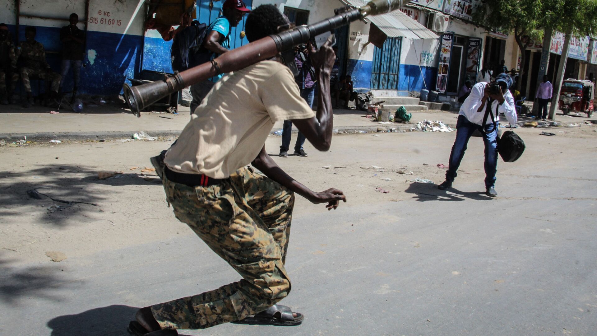 شخص يلتقط صورة لعضو في القوة العسكرية الصومالية يدعم المناوئين للحكومة أثناء وقوفه في أحد شوارع مقديشو، الصومال، 25 أبريل 2021 - سبوتنيك عربي, 1920, 06.09.2021