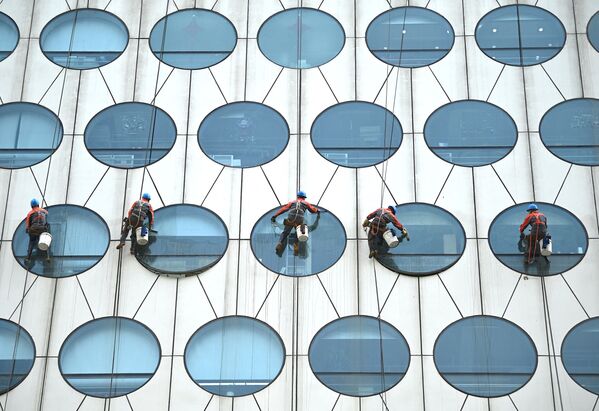عمال ينظفون نوافذ أحد المباني في بكين في الصين 12 مايو 2021 - سبوتنيك عربي