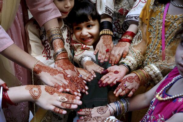 فتيات يظهرن أيديهن مرسومة بالحناء التقليدية تكريما لعيد الفطر في بيشاور، باكستان 13 مايو 2021 - سبوتنيك عربي