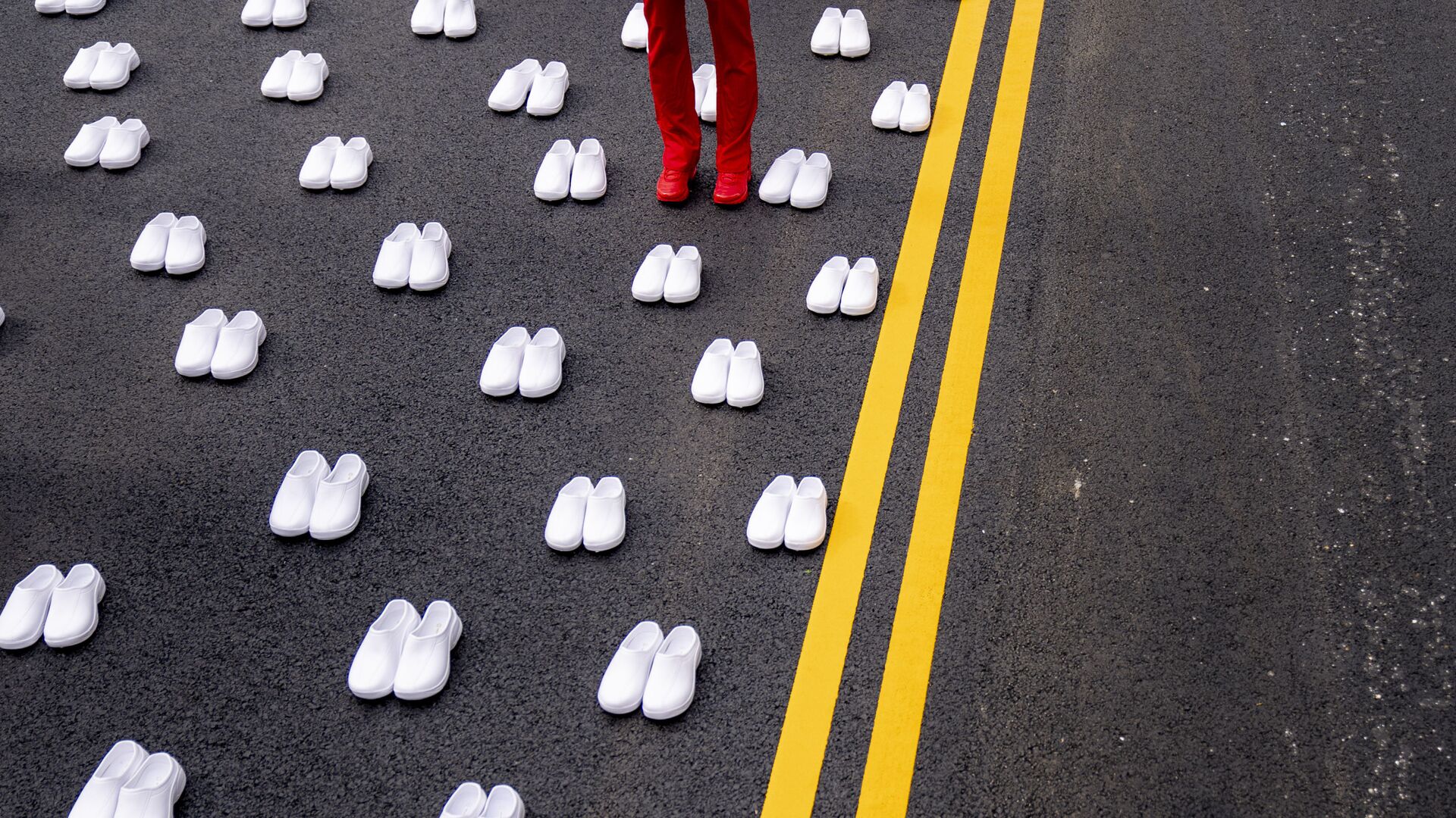 امرأة ترتدي زي الممرضات تقف محاطة بأزواج من الأحذية البيضاء لتمثيل 402 ممرضة توفيت بسبب كوفيد -19، بالقرب من البيت الأبيض في واشنطن، 12 مايو 2021. - سبوتنيك عربي, 1920, 17.03.2023
