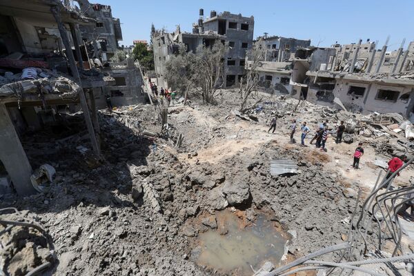 فلسطينيون يتجمعون حول مواقع منازلهم المقصوفة في شمال قطاع غزة، فلسطين 14 مايو 2021 - سبوتنيك عربي