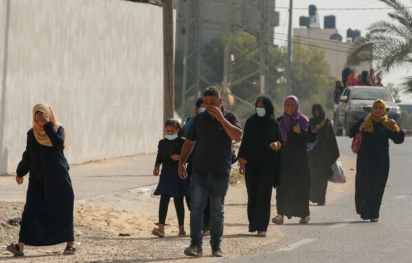 فلسطينيون يخلون أحياءهم بعد اشتداد قصف المدافع والطيران الحربي الإسرائيلي في شمال قطاع غزة، فلسطين 14 مايو 2021 - سبوتنيك عربي