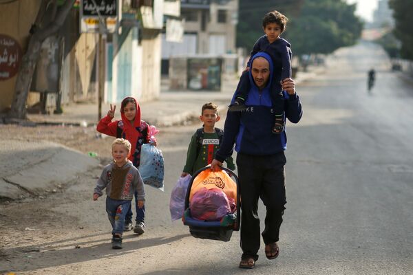 فلسطينيون يخلون أحياءهم بعد اشتداد قصف المدافع والطيران الحربي الإسرائيلي في شمال قطاع غزة، فلسطين 14 مايو 2021 - سبوتنيك عربي