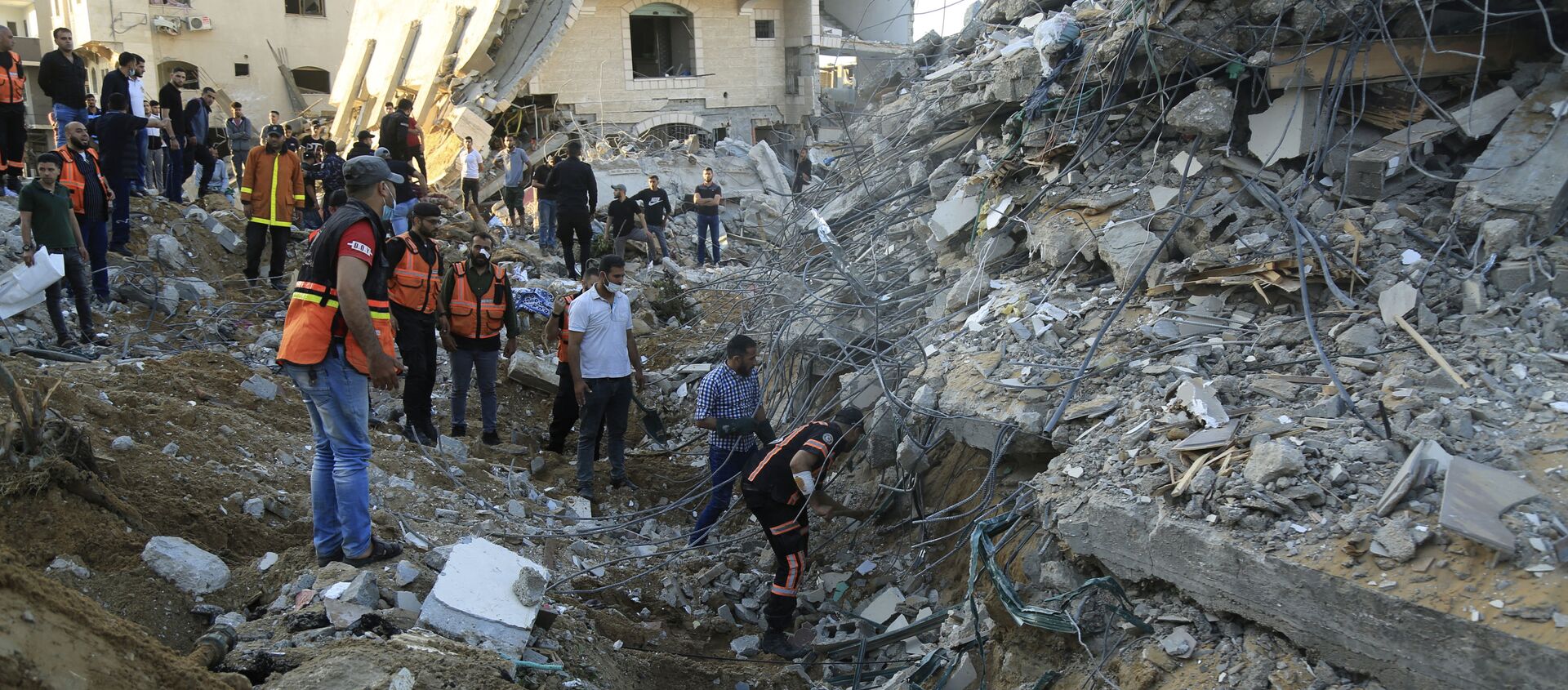 فلسطينيون يتجمعون حول مواقع منازلهم المقصوفة في بيت لاهيا، شمال قطاع غزة، فلسطين 13 مايو 2021 - سبوتنيك عربي, 1920, 15.05.2021
