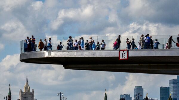 أشخاص يتنزهون على الجسر المعلق (بورياشي) بالقرب من الكرملين وسط مدينة موسكو، روسيا 17 مايو 2021 - سبوتنيك عربي