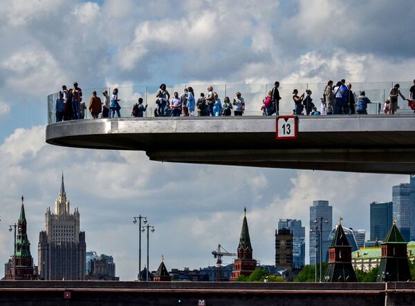 أشخاص يتنزهون على الجسر المعلق (بورياشي) بالقرب من الكرملين وسط مدينة موسكو، روسيا 17 مايو 2021 - سبوتنيك عربي