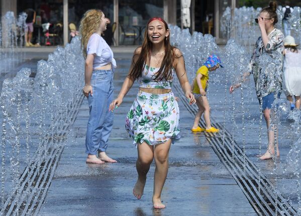 فتيات يركضن وسط نافورة مياه في حديقة موزيون وسط موسكو مع تسجيل درجة حرارة وصلت 29 درجة مئوية، روسيا 17 مايو 2021 - سبوتنيك عربي