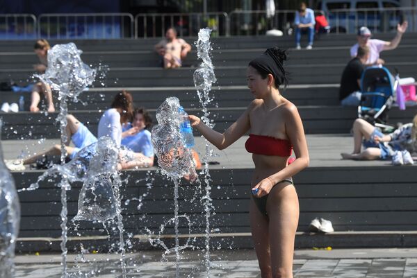 فتاة تقف وسط نافورة مياه في حديقة موزيون وسط موسكو مع تسجيل درجة حرارة وصلت 29 درجة مئوية، روسيا 17 مايو 2021 - سبوتنيك عربي