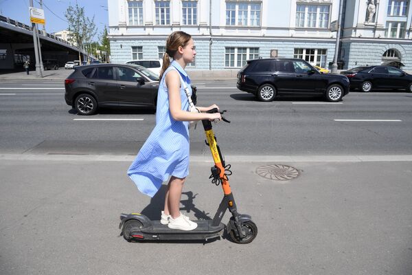 فتاة تركب سكوتر آلي في شارع أستوجينكا وسط مدينة موسكو، روسيا 17 مايو 2021 - سبوتنيك عربي
