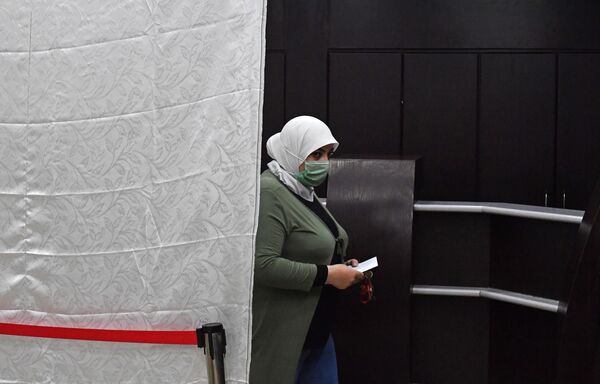 امرأة تشارك في التصويت في الانتخابات الرئاسية السورية في دمشق، سوريا 26 مايو 2021 - سبوتنيك عربي