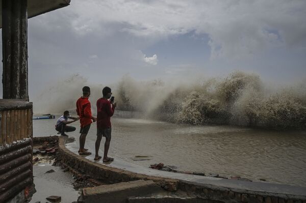 أهالي سكان كلكتا يلتقطون صوراً لأمواج تضرب الشاطئ عقب إعصار ياس الذي ضرب الساحل الشرقي للهند في خليج بنغال في ديغا، الهند 27 مايو 2021 - سبوتنيك عربي