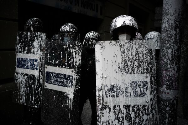 متظاهرون يلقون بعبوات طلاء أبيض على عناصر شرطة مكافحة الشغب، خلال احتجاجات في برشلونة ضد إخلاء الناشط الشاب أكسيل ألتاديل (28 عام) من غرفة سكنه (منذ يناير 2019)، إسبانيا 25 مايو 2021 - سبوتنيك عربي