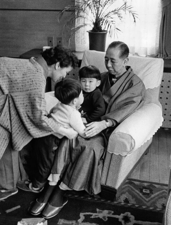 صورة عائلية لنوبوسوكي كيشي، رئيس وزراء اليابان وزوجته ريوكو في زي ياباني تقليدي (كيمونو) مع حفيدهما شينزو آبي (رئيس وزراء اليابان السابق) وهيرونوبو آبي (في حضن جده). - سبوتنيك عربي
