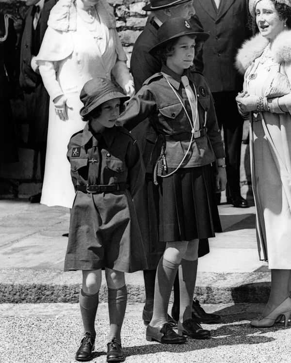 التقطت الصورة عام 1938 في قلعة وندسور، حيث تظهر الأميرات مارغريت وإليزابيث (الملكة إليزابيث الثانية)، خلال مسيرة للفتيات الكشافة. - سبوتنيك عربي