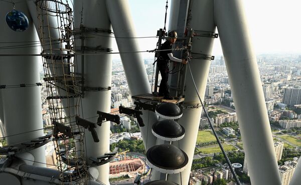 تحدي السير على الحبال في الجو في برج كانتون الصيني، في مدينة قوانغتشو، الصين 23 مايو 2021 - سبوتنيك عربي