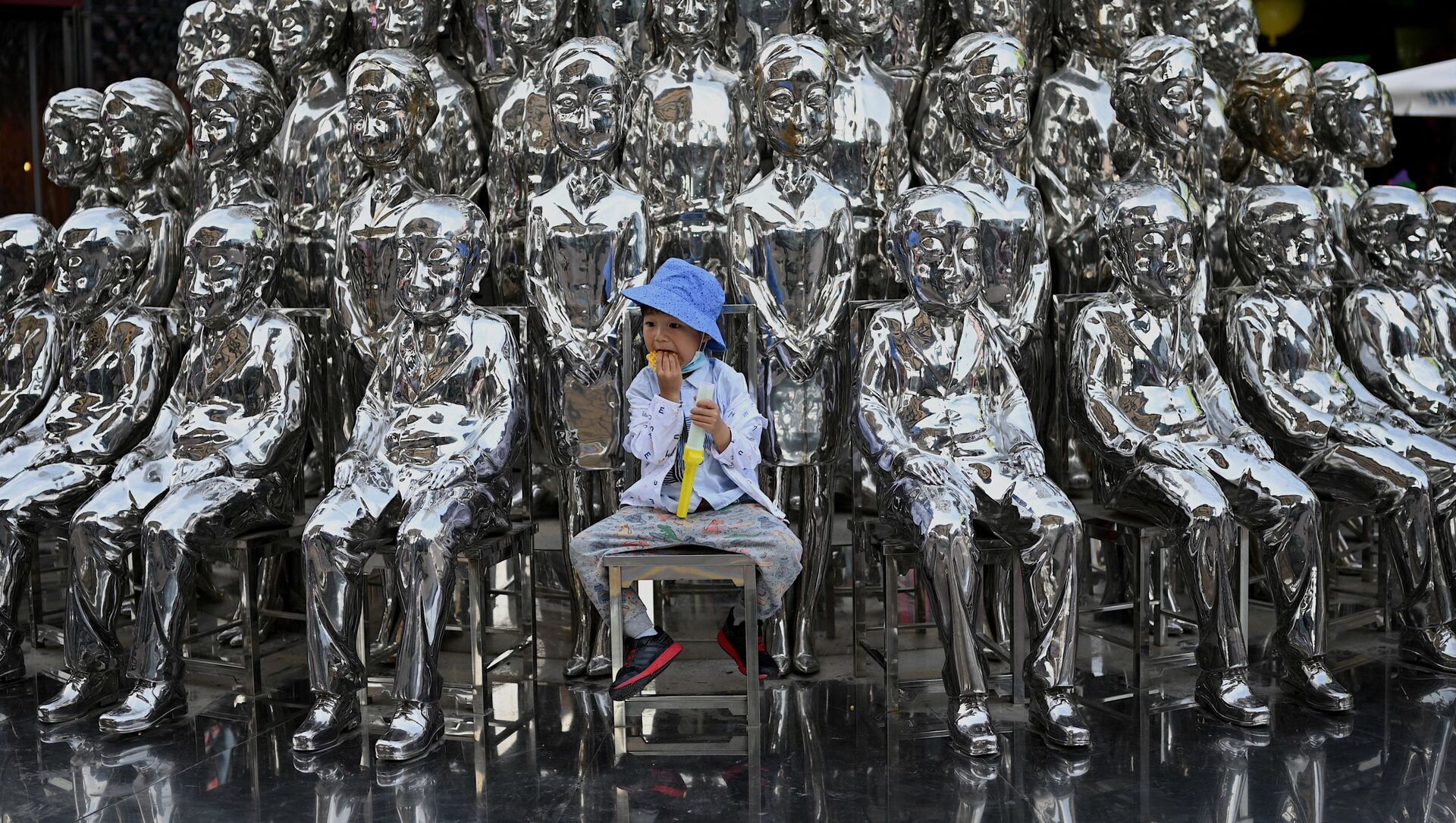 صبي يجلس على كرسي بين منحوتات معروضة في مركز تسوق في يوم الطفل العالمي في بكين في الأول من يونيو 2021، بعد يوم من إعلان الصين بالسماح للأزواج بإنجاب ثلاثة أطفال. - سبوتنيك عربي, 1920, 29.10.2021