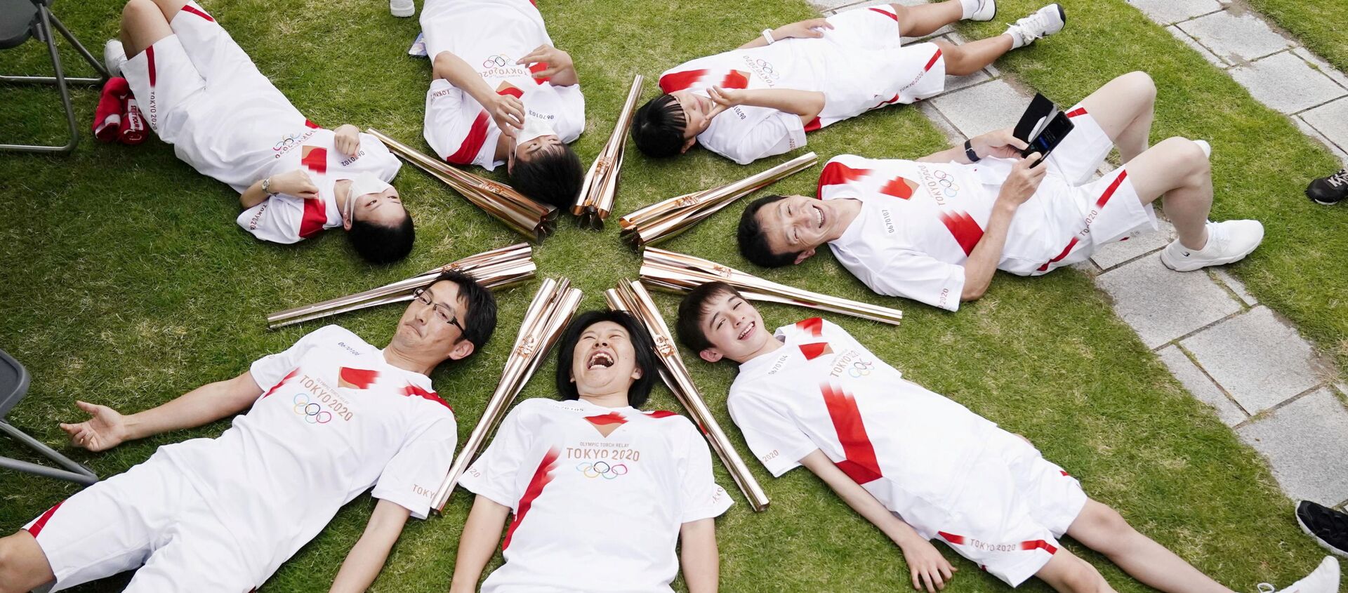 المشاركون في سلسلة تتابع شعلة أولمبياد طوكيو يستلقون في دائرة خلال استراحة في توياما باليابان في 3 يونيو 2021 - سبوتنيك عربي, 1920, 20.06.2021