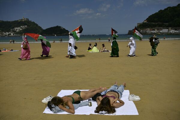 متظاهرون من الصحراء يلوحون بأعلام في مسيرة على الشاطئ في سان سيباستيان، إسبانيا 30 مايو 2021 - سبوتنيك عربي